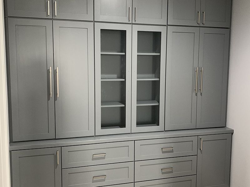 Floor to ceiling steel gray cabinets with gold handles